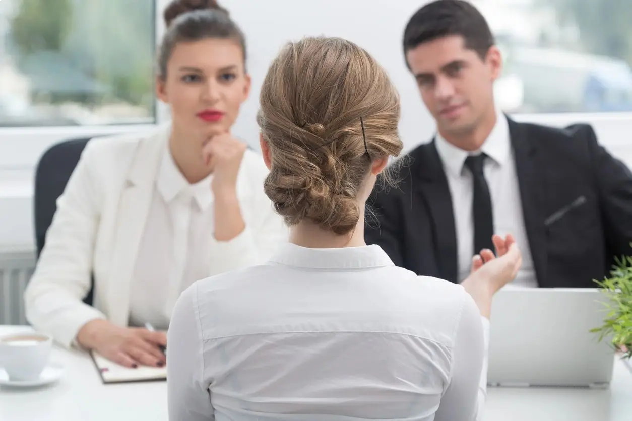 A woman is sitting in front of two men.